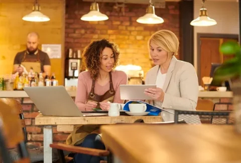SMB owner discussing her small business bank account with her banker. GETTY